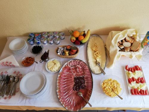 Una mesa con muchos tipos diferentes de comida sobre ella. en GOSTILNA S PRENOČIŠČI PAV, en Rakek