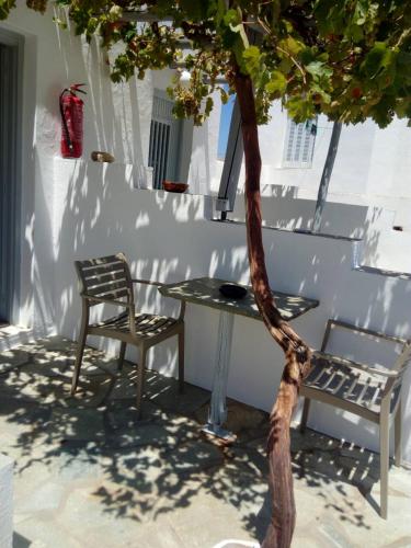 a table and a chair next to a tree at Themonia in Apollonia