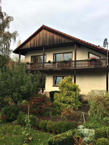 a house with a balcony on top of a garden at Pension Anna in Löbau