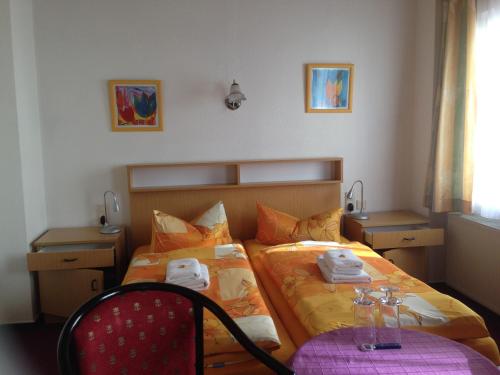 - une chambre avec un lit et des serviettes dans l'établissement Pension Anna, à Löbau