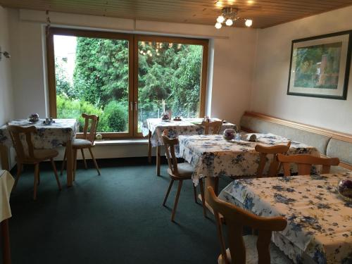 a dining room with tables and a large window at Pension Anna in Löbau