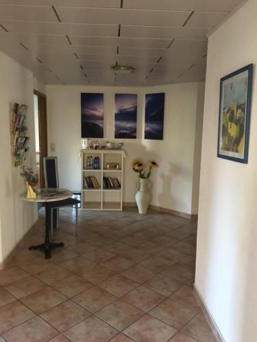 a room with a table and a vase on a tile floor at Pension Anna in Löbau