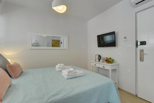 a bedroom with a bed with towels on it at D&A Amphitheatre Apartments with free parking in Pula