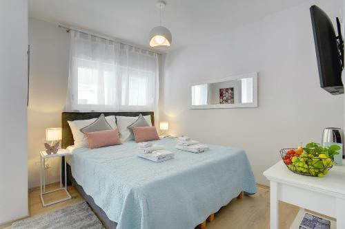 a bedroom with a large bed with a blue blanket at D&A Amphitheatre Apartments with free parking in Pula