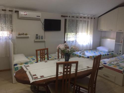a dining room with a table and chairs and two beds at Lille France Apartments in Shkodër