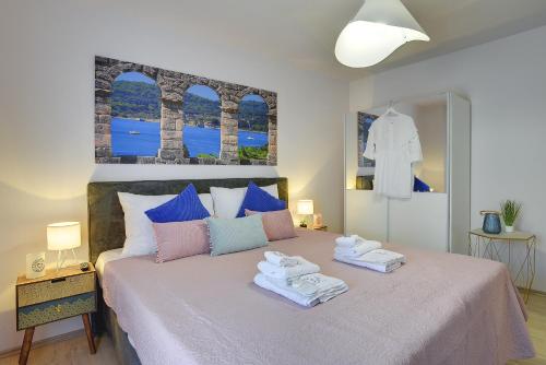 a bedroom with a bed with towels on it at D&A Amphitheatre Apartments with free parking in Pula
