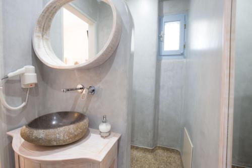 a bathroom with a sink and a mirror at Erato Apartments in Firostefani