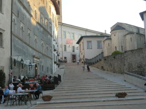 a group of people sitting at tables in an alley at Albornoz Palace Hotel in Spoleto