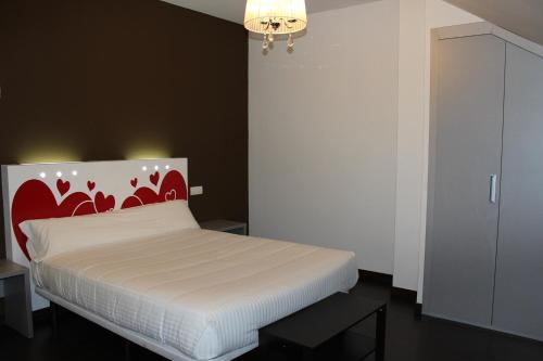a bedroom with a bed with a red and white headboard at Calas De Liencres in Liencres