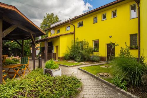 a yellow house with a garden in front of it at Penzion Anareta in Frýdek-Místek