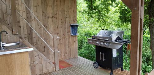 - une cuisine extérieure avec un grill et un évier dans l'établissement Cabane Perchée dans la prairie de l'ancien moulin, à Valmont