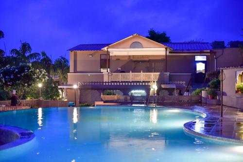 a swimming pool in front of a house at night at Araliayas Resort & Spa in Udaipur