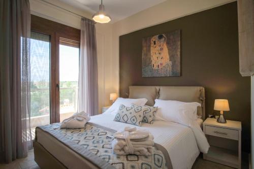 a bedroom with a bed with towels on it at Saint Paul's Residences in Sani Beach