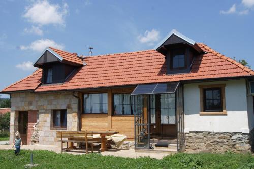 una casa con tetto rosso e tavolo da picnic di Guest House Glogovac a Kamenica
