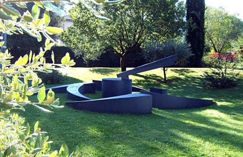 a park with a sculpture in the grass at Albornoz Palace Hotel in Spoleto