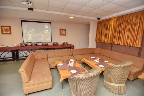 ein Wohnzimmer mit einer Couch und einem Tisch mit Stühlen in der Unterkunft Araliayas Resort & Spa in Udaipur