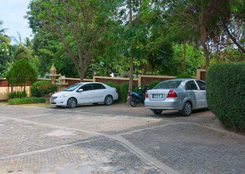 two cars and a motorcycle parked in a parking lot at Samui Green Life in Bophut 