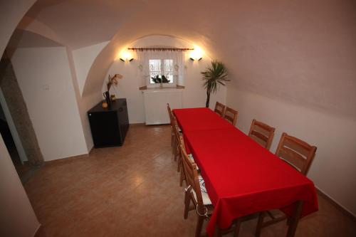 a dining room with a red table and chairs at Penzion U Haničky in Rožmberk nad Vltavou