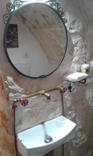 a bathroom with a mirror and a white sink at B&B Luxury Villa Olimpia Home Restaurant in Selva di Fasano