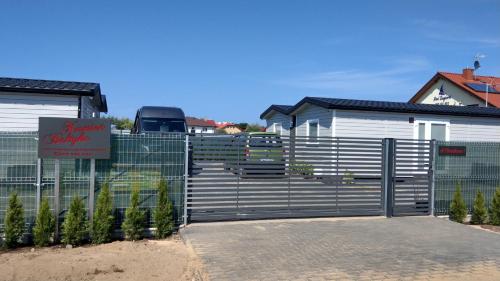 a fence with a gate in front of a house at Kamień Bałtyku Rowy in Rowy