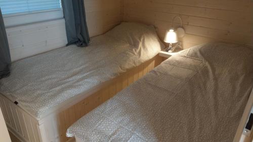 2 camas en una habitación con lámpara y ventana en Kamień Bałtyku Rowy, en Rowy