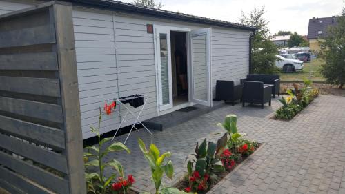 a small house with a patio and flowers at Kamień Bałtyku Rowy in Rowy