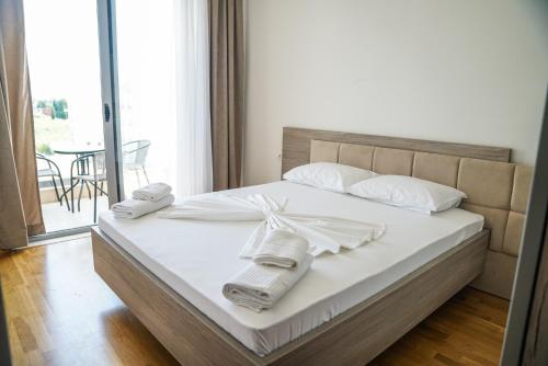 1 dormitorio con 1 cama con toallas en La Dolce Vita Residence, en Ulcinj