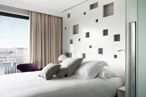 a bedroom with a white bed with a window at BW Premier Collection Le Saint Antoine Hotel et Spa in Rennes