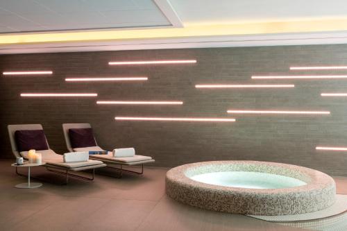 a lobby with a large bath tub and chairs at BW Premier Collection Le Saint Antoine Hotel et Spa in Rennes