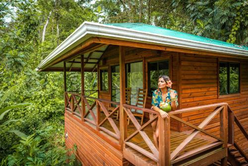 a woman standing on the porch of a tiny house at Palmar Beach Lodge in Bocas Town