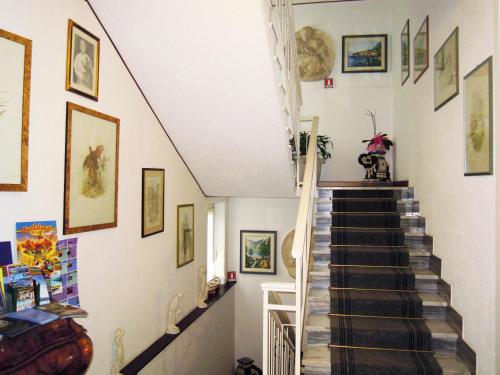 a staircase in a house with paintings on the walls at Hotel Villa Margherita in Limone sul Garda