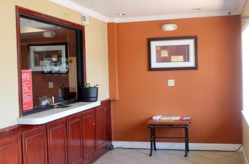 a bathroom with an orange wall with a sink and a table at Fairview Inn Wilmington in Wilmington
