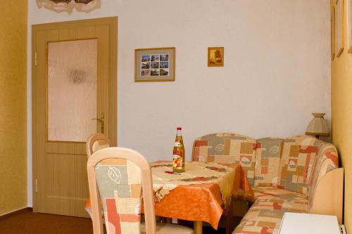 a room with a table and chairs and a bottle of beer at Zum Dorfschullehrer in Lübbenau