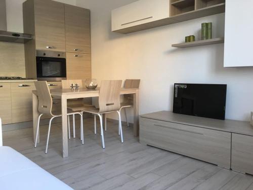 a kitchen with a table and chairs and a television at Bed&Beach in Scauri
