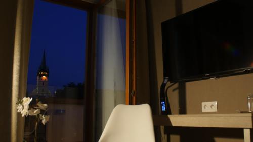 a room with a window with a view of a clock tower at Penzion ZENIT in Prešov