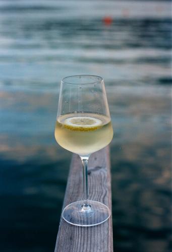 a glass of wine sitting on top of a wooden rail at Landhaus Alfred Wunder in Pörtschach am Wörthersee