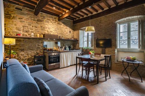 a living room with a couch and a table and a kitchen at Casa Zeni in Cortona