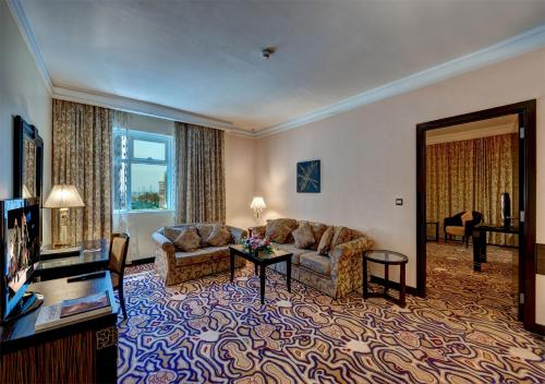 a living room with a couch and a table at Sharjah Palace Hotel in Sharjah