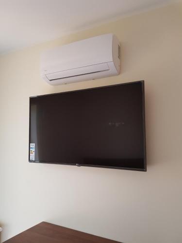 a flat screen tv hanging on a wall at Apartamenty Dom Saski 10 minut od Centrum Warszawy in Warsaw