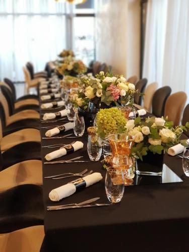 a long table with vases and flowers on it at Royal G Hotel and Spa in Durrës