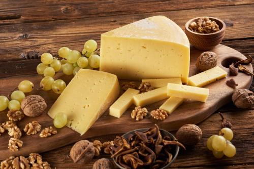 a wooden cutting board with cheese and grapes and nuts at Tourist farm Mulej in Bled