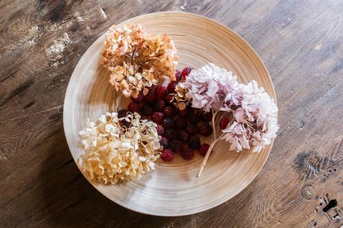 a plate with flowers and berries on a wooden table at Casa Zeni in Cortona