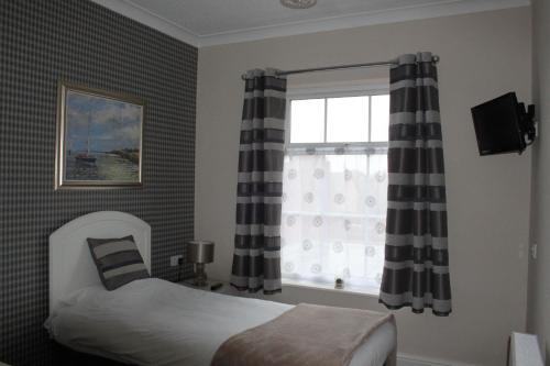 A bed or beds in a room at Abbey Grange Hotel 