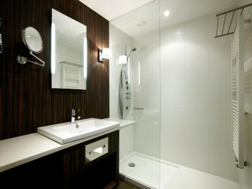 a bathroom with a sink and a shower at Krasnapolsky Apartments in Amsterdam