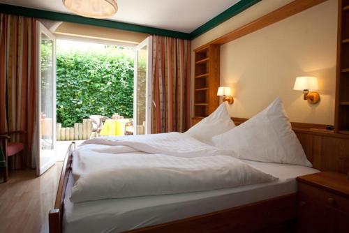 a bedroom with a large white bed with a window at Ferienwohnungen Kärnten Dr. Baumgartner in Faak am See