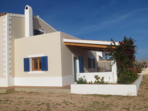 a white house with blue windows and a plant at Casa Rural Ideal para Parejas - Formentera in Sant Francesc Xavier