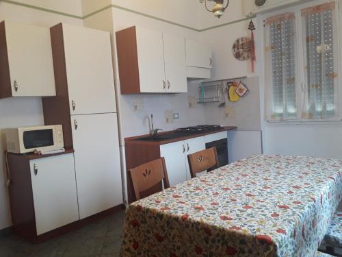 a kitchen with white cabinets and a table and a kitchen gmaxwell gmaxwell gmaxwell at La bomboniera in Imperia