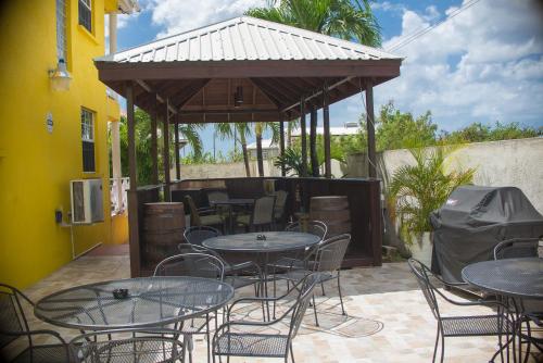 a patio with tables and chairs and a pavilion at Best E Villas Prospect St James in Saint James