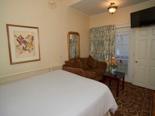 a bedroom with a bed and a chair and a window at Bellevue House in Newport