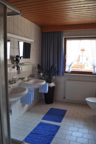 a bathroom with two sinks and a window at Apart Gerlinde in See